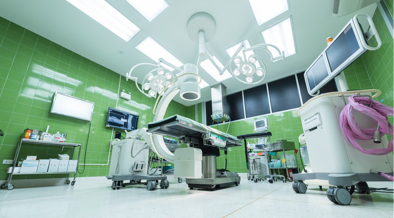 Operating room with surgical table, imaging equipment, and overhead lights