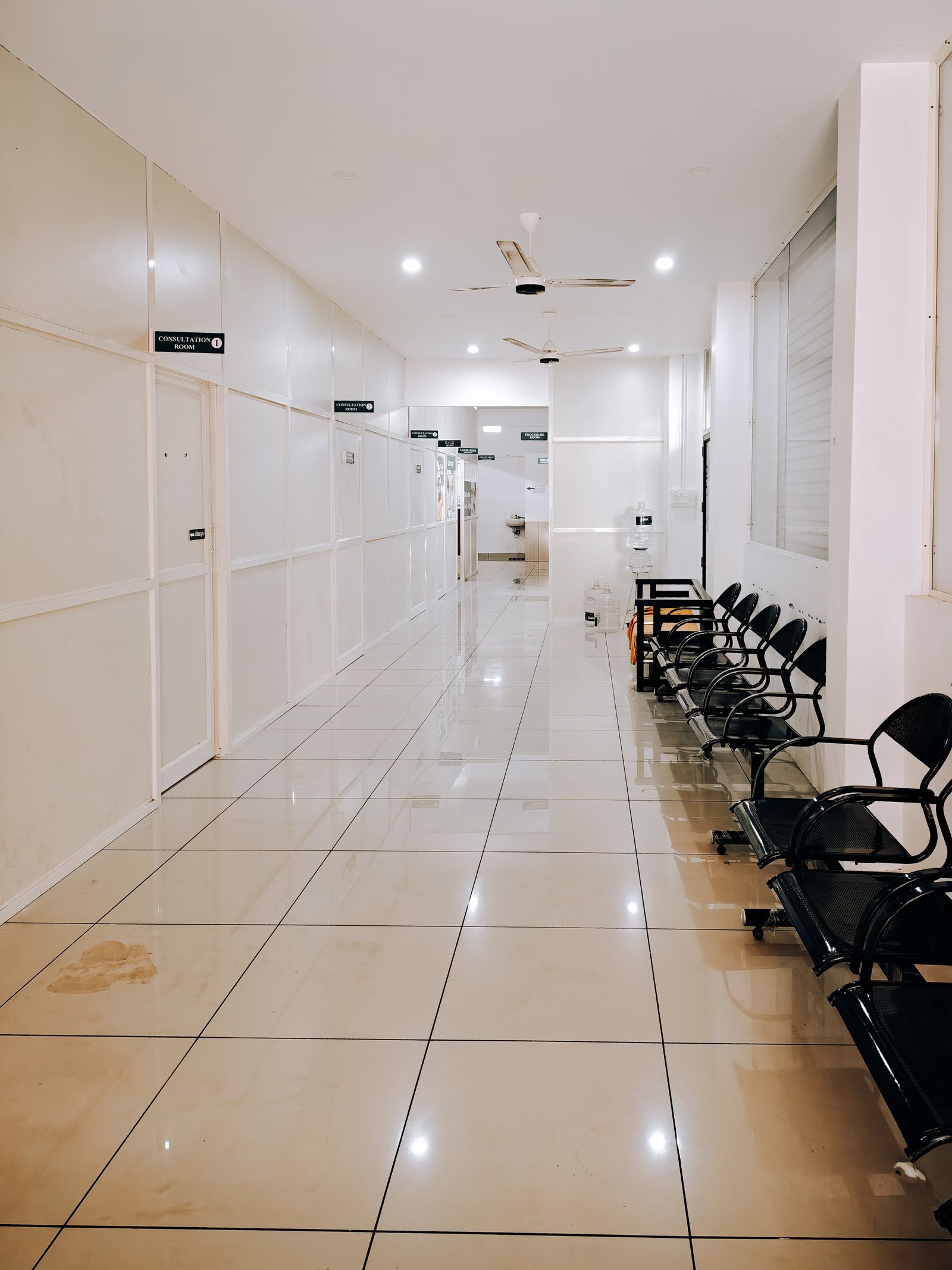 Clinic corridor with consultation rooms and waiting chairs