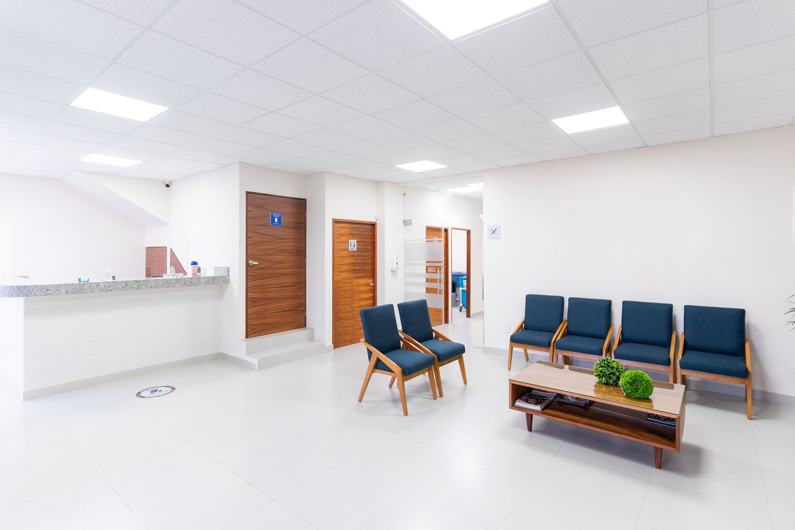 Bright outpatient waiting room with seating and a reception desk