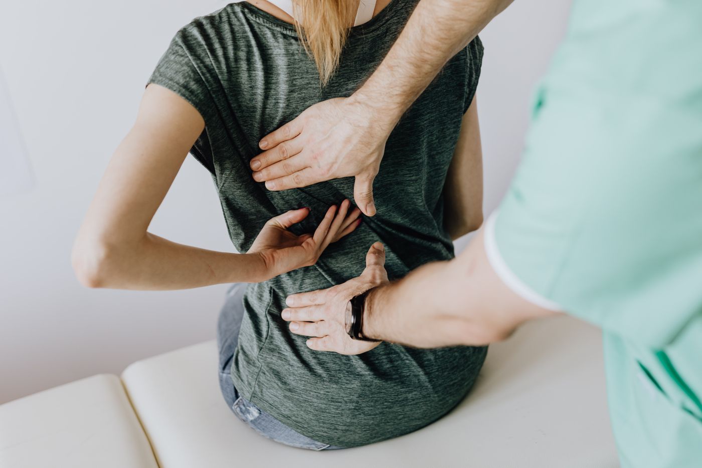 Clinician examining a patient’s back during a spinal evaluation