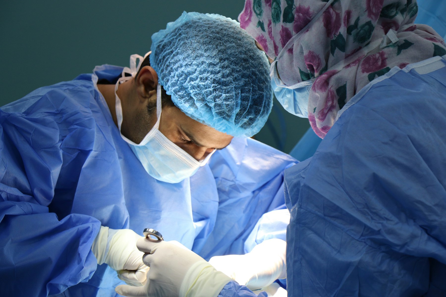 Surgical team in gowns and masks working together in an operating room